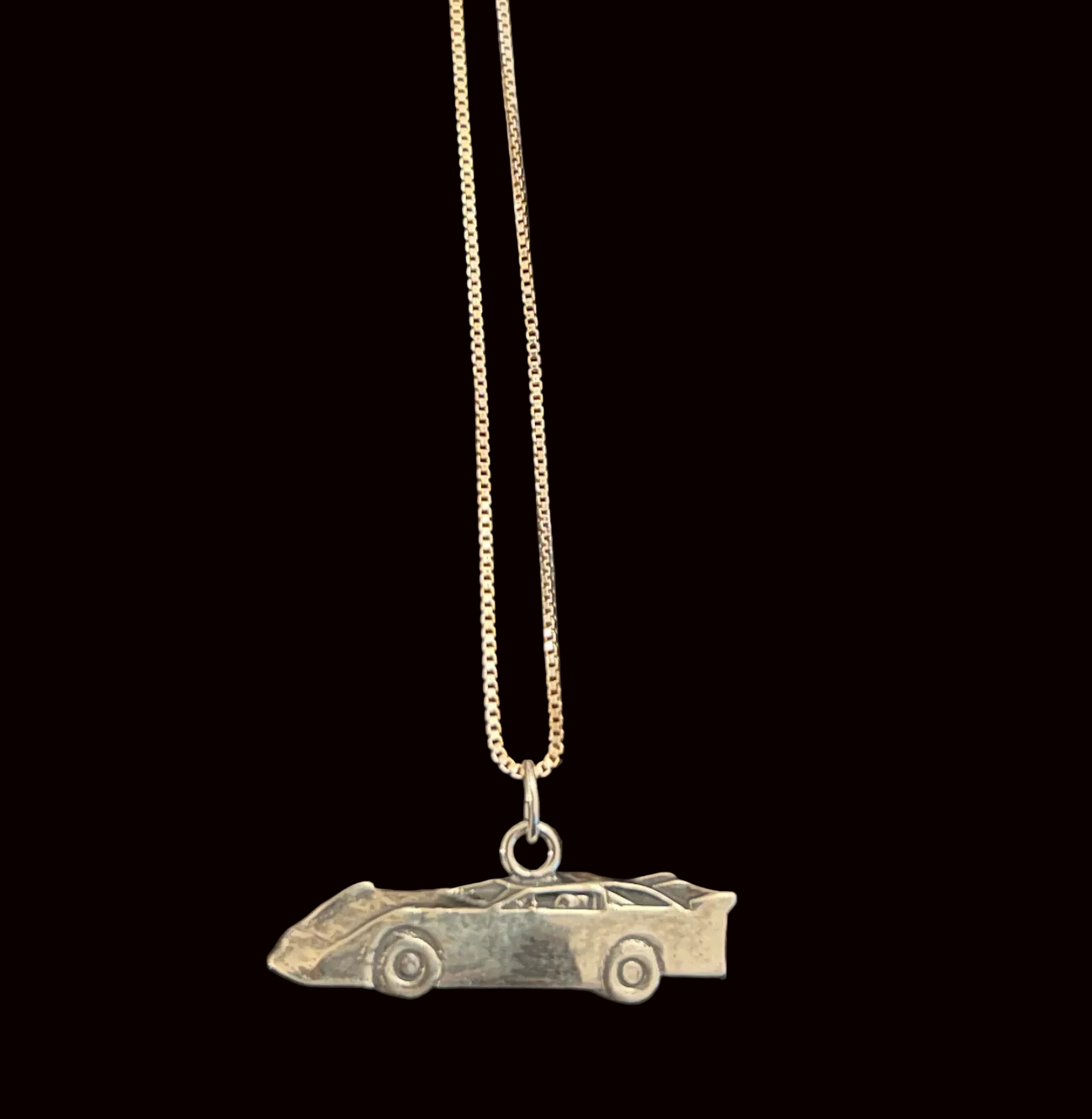 Necklace with a car-shaped pendant on a black background